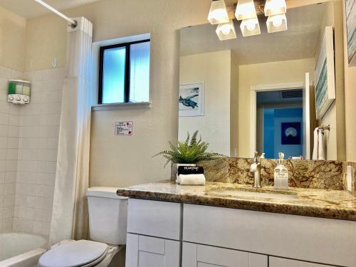 a bathroom with a sink and a toilet and a mirror at DT Reno - 4BR Home with Patio, BBQ Grill, Games Room in Reno