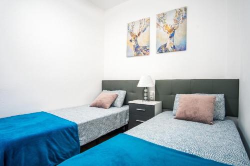 two beds in a room with blue and pink at Apartament Glamour La Mata in Torrevieja