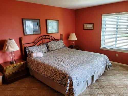 - une chambre avec un lit aux murs rouges et 2 lampes dans l'établissement Anchorage I 104, à Myrtle Beach