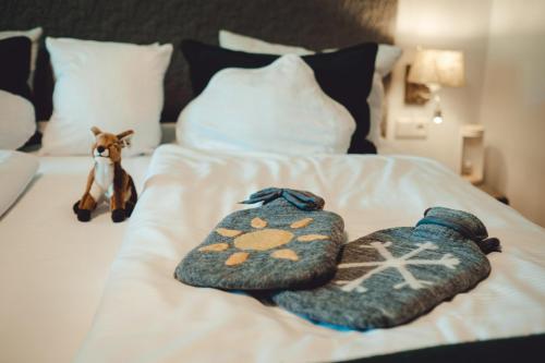 a bed with two knitted towels on it at Berghotel Rehlegg in Ramsau