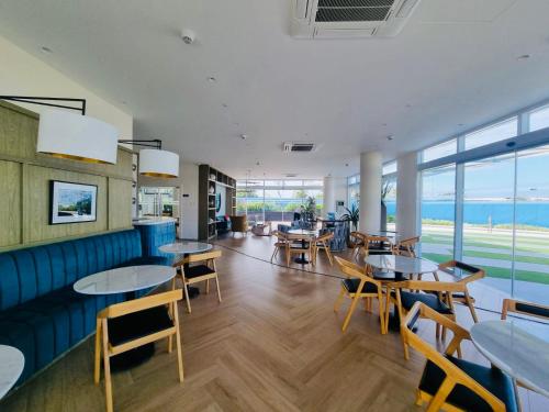 聖弗南多的住宿－Sonne & Strand AZURE NORTH PAMPANGA，一间设有桌椅的海洋餐厅