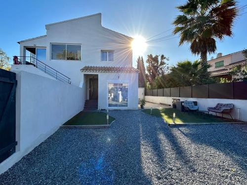 une maison blanche avec une clôture et une cour dans l'établissement Charmant Studio dans villa - parking - jardin, à La Seyne-sur-Mer