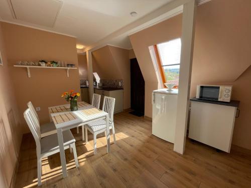 a kitchen and dining room with a table and chairs at Kétpáva Vendégház in Igal