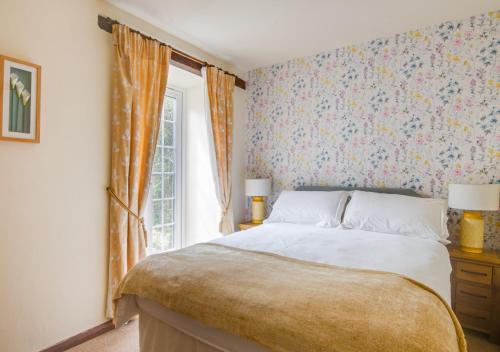 a bedroom with a large bed and a window at The Dairy in Llanerchymedd