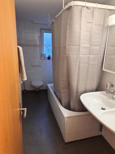 ein Badezimmer mit einer Badewanne, einem WC und einem Waschbecken in der Unterkunft Hotel Mam in St. Gallen
