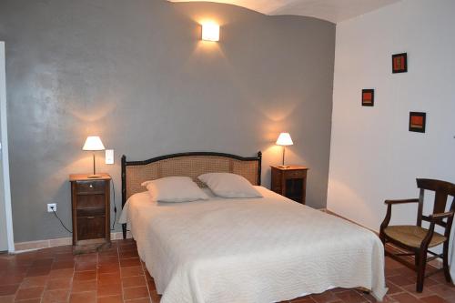a bedroom with a bed and two chairs and two lamps at a Casa in Calenzana