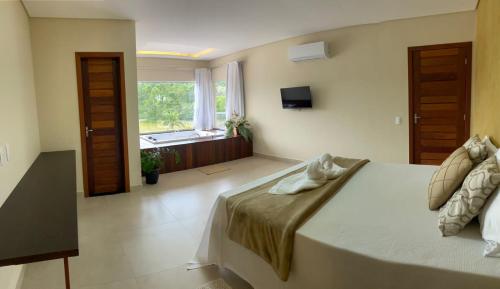 a bedroom with a large bed and a window at Pousada Peninsula Santa Rita in Guarapari