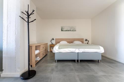 1 dormitorio blanco con 1 cama y suelo en De Hoog Velden 12, en Neerpelt