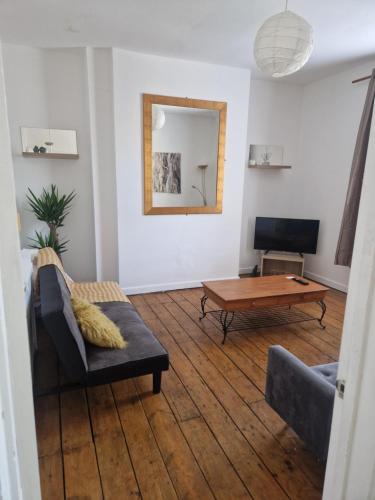 ein Wohnzimmer mit einem Sofa und einem Tisch in der Unterkunft 13 Grosvenor House, in Bristol