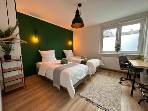 - 2 lits dans une chambre dotée d'un mur vert dans l'établissement Business Suites-Fair-Balcony's-Uniklinik - for 8, à Essen