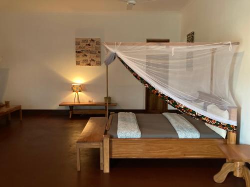 a bedroom with a bed with a mosquito net at Camp Bastian Mikumi in Mikumi