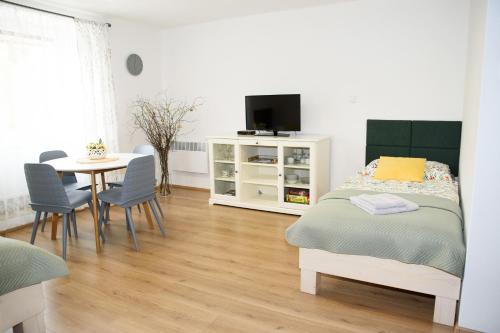um quarto com uma cama e uma mesa com cadeiras em Apartmán Mločí údolí • Podyjí em Znojmo