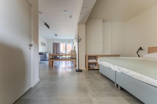 a bedroom with a large bed and a living room at De Hoog Velden 12 in Pelt