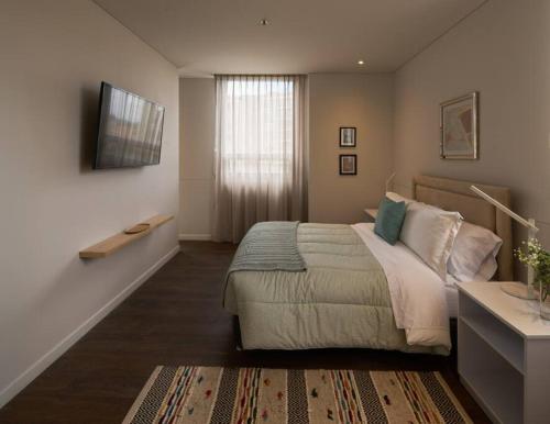 a bedroom with a bed and a television on a wall at Caluce Apt 3A by Letoh in Chía