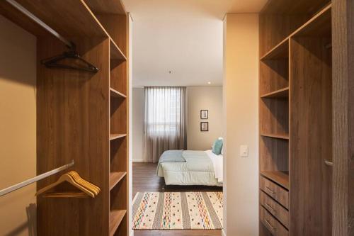 a bedroom with a bed and a large wooden closet at Caluce Apt 3A by Letoh in Chía