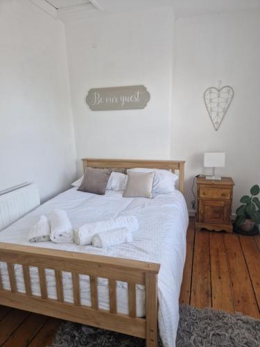 um quarto com uma cama com lençóis brancos e almofadas em 13 Grosvenor House, em Bristol