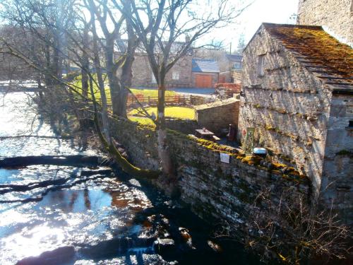 a stone wall next to a river next to a building at Riverside Bed & Breakfast in Bainbridge