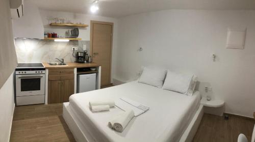 - une chambre avec un grand lit blanc et des serviettes dans l'établissement Naxian Vibes Apartments, à Naxos Chora