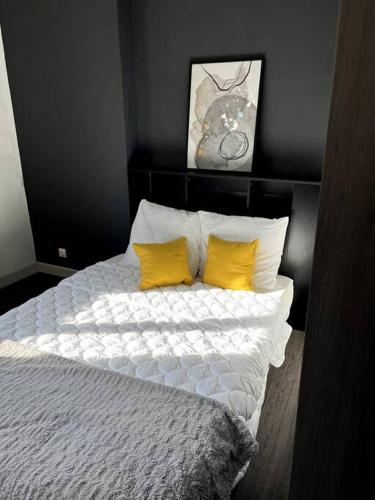 1 dormitorio con 1 cama con 2 almohadas amarillas en Frontière Monaco Large 2 rooms 5 mins to casino !, en Beausoleil