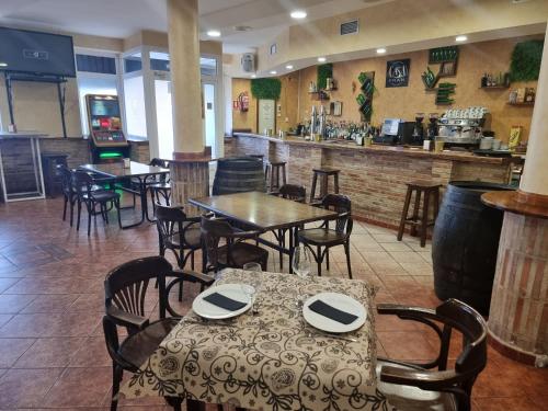 ein Restaurant mit Tischen und Stühlen und eine Bar in der Unterkunft Hostal Restaurante CASA FRAN in La Pueblanueva