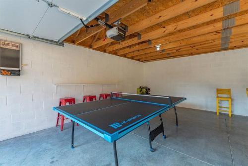 a ping pong table in a room with red chairs at Fully Stocked Cabin Retreat w/ Game Room & Pond! in Marion