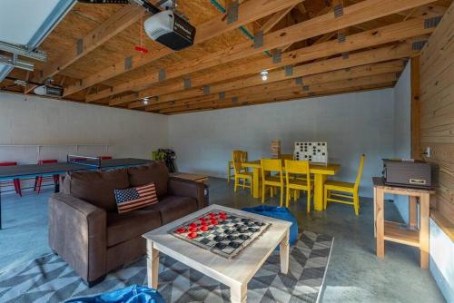 a living room with a couch and a ping pong table at Fully Stocked Cabin Retreat w/ Game Room & Pond! in Marion
