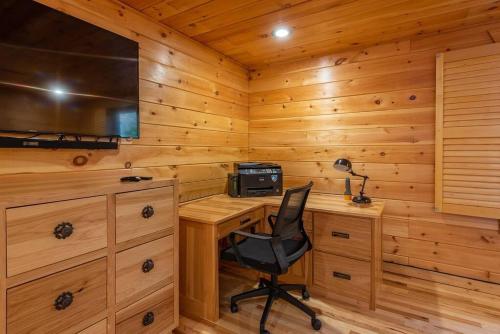 a desk with a computer and a chair in a cabin at Fully Stocked Cabin Retreat w/ Game Room & Pond! in Marion