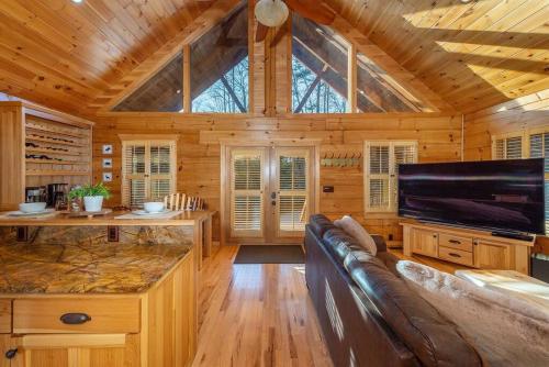 uma sala de estar com um sofá e uma televisão numa cabina em Fully Stocked Cabin Retreat w/ Game Room & Pond! em Marion