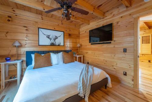 a bedroom with a bed and a ceiling fan at Fully Stocked Cabin Retreat w/ Game Room & Pond! in Marion