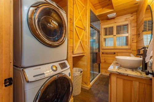 a bathroom with a washing machine and a sink at Fully Stocked Cabin Retreat w/ Game Room & Pond! in Marion