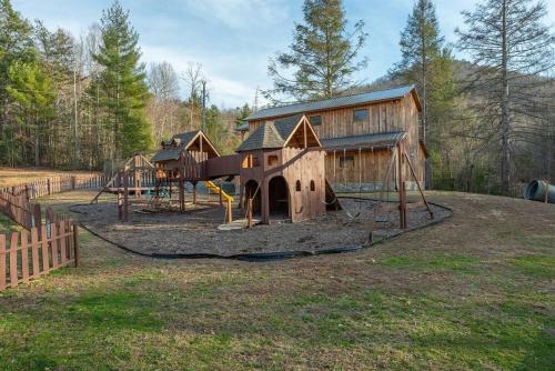 a playground with a wooden building and a play yard at Fully Stocked Cabin Retreat w/ Game Room & Pond! in Marion