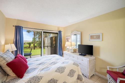 um quarto com uma cama, uma televisão e uma janela em Plantation Palms 6110 by ALBVR - Upgraded Ground Floor Beachfront Condo - Lots of Amenities em Gulf Highlands