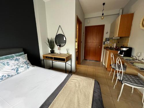 a bedroom with a bed and a table and a kitchen at B6 COQUETTE in Nea Chili