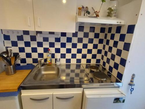 une cuisine avec un évier et une cuisinière dans l'établissement Maisonnette studio mezzanine avec piscine chauffée, proche plage et commerces - St Jean de Monts - FR-1-323-269, à Saint-Jean-de-Monts