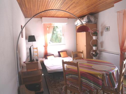 Cette chambre comprend une table, un lit et une fenêtre. dans l'établissement Studio Charmant avec Balcon et Parking à 300m de la Plage - FR-1-712-43, à Villers-sur-Mer