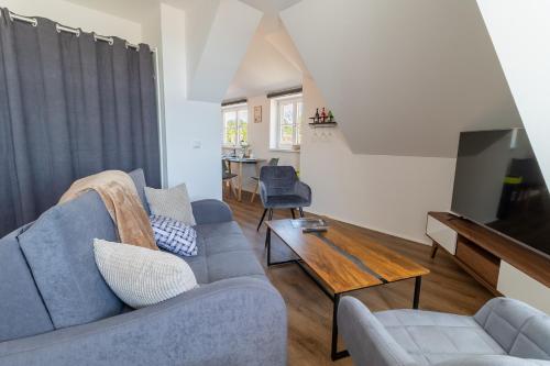 uma sala de estar com um sofá azul e uma mesa em Daniels Apartment an der Schloßbrücke em Meissen