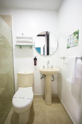 a bathroom with a toilet and a sink and a mirror at Greenview Medellin By St Hoteles in Medellín