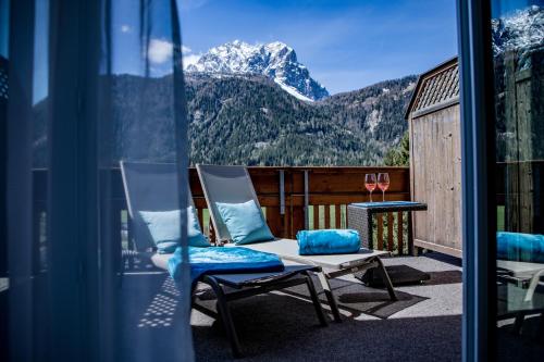 a balcony with chairs and a view of a mountain at Hotel Gruber in Sesto