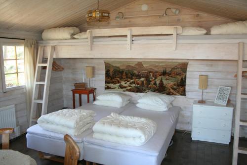 a bedroom with two beds and a painting on the wall at Tofvehults Boende in Skaftet