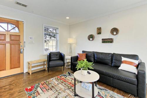 a living room with a black leather couch and a table at Beautiful 3br 2ba Colonial House CozySuites in Alexandria