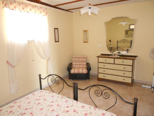 1 dormitorio con cama, tocador y espejo en Casa Brigante, en Torre Pali