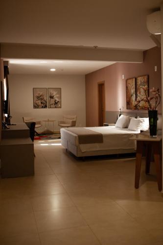 ein Schlafzimmer mit einem großen Bett und einem Tisch in der Unterkunft Bristol Infinity Rio Claro in Rio Claro