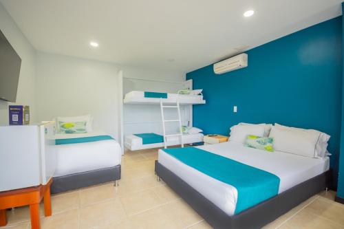 1 dormitorio con 2 camas y pared azul en Greenview Medellin By St Hoteles, en Medellín