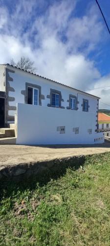 a white building with blue windows on the side of it at Fazenda Apartments - Apartment 1 in Lajes das Flores