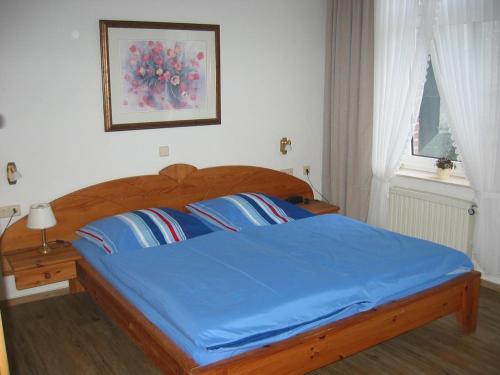 a bedroom with a bed with blue sheets and a window at Gelder Dyck in Kevelaer
