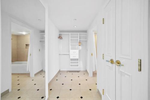 a bathroom with a white door and a tile floor at 2BR 3BA Beachfront Rental in Town CozySuites in Atlantic City