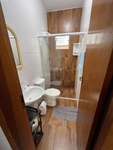 a bathroom with a shower and a toilet and a sink at Casa região central Guaratuba in Guaratuba