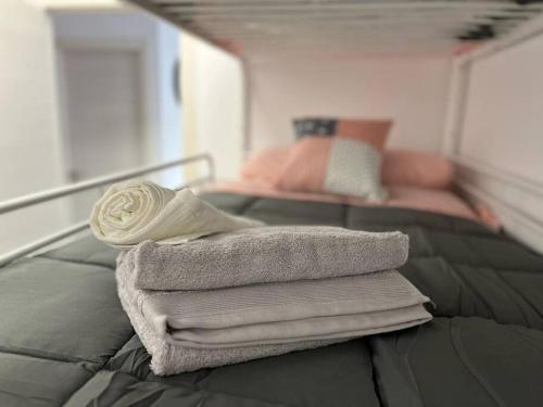 una pila de toallas sentadas encima de una cama en PB Apartamento en pleno centro de Alcoy, en Alcoy