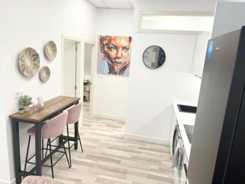 a dining room with a table and a clock on the wall at PB Apartamento en pleno centro de Alcoy in Alcoy