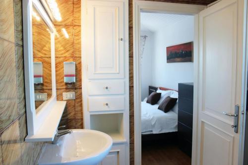 a bathroom with a sink and a bedroom at Villa Roma Holidays in Jesolo